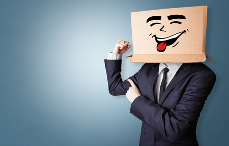 Young boy with happy cardboard box faceの写真素材