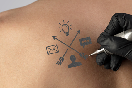 Tattooing communication, leadership and creativity  concept on naked backの写真素材