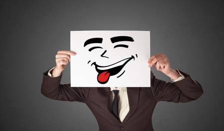 Person holding a paper with cool emoticon faceの写真素材