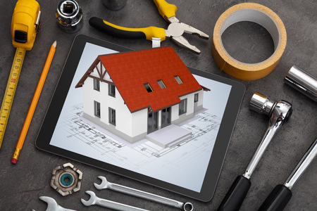 Tablet with construction tools and 3d home plan conceptの写真素材