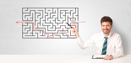 Businessman presenting a maze on a wallの写真素材