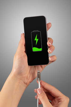 Elegant hand charging cellphone with low batteryの写真素材