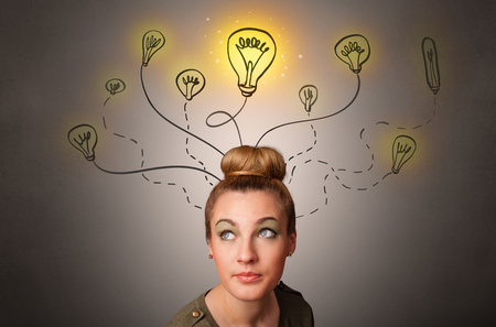 Pretty girl with draw bulbs above her head with different solutions conceptの写真素材