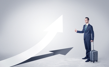 Young businessman hitchhiking with progressive arrow concept and copyspaceの写真素材