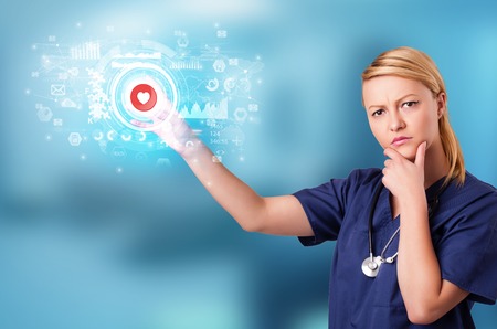 Doctor touching hologram screen displaying medical symbols and chartsの写真素材