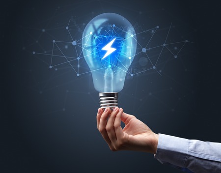 Hand holding light bulb on dark background. Networking idea conceptの写真素材