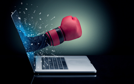 Hand with box gloves coming out of a laptop with sparkling effectsの写真素材