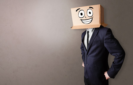 Young boy standing and gesturing with a cardboard box on his headの写真素材