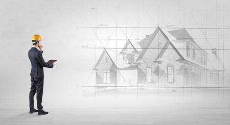 Architect standing and watching an imagined house planの写真素材