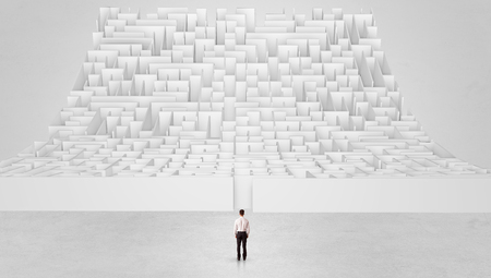 Businessman standing and thinking in front of a curved infinity mazeの写真素材