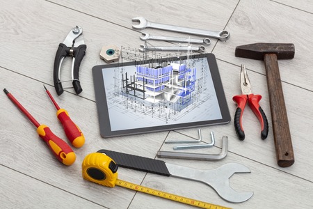 Tablet with construction tools and 3d house plan conceptの写真素材