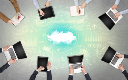 Group of people with devices in hands working on reports with online teamwork and cloud technology conceptの写真素材