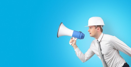 Young architect constructor yelling with megaphone and copyspaceの写真素材