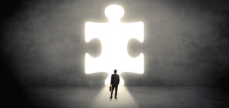 Businessman  standing and looking to a big puzzle pieceの写真素材