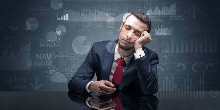 Young businessman sleeping with charts, graphs and reports on the backgroundの写真素材