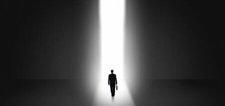 Businessman standing and seeing the light at the end of a big wallの写真素材