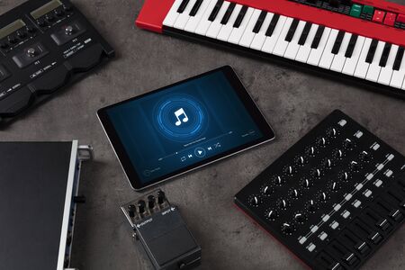 Playing song on tablet with electronic music instruments aroundの写真素材