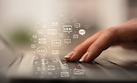 Business woman hand typing on keyboard with chat icons aroundの写真素材