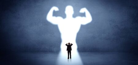 Businessman standing and dreaming about a strong superheroの写真素材