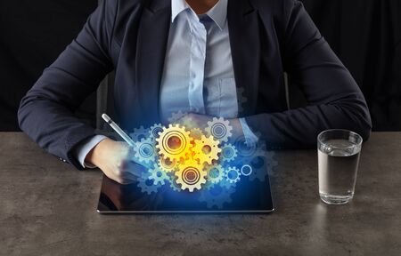 Business woman working on tablet with setting and gear conceptの写真素材