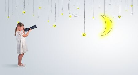 Cute little girl looking through spyglass to lighting bulbsの写真素材