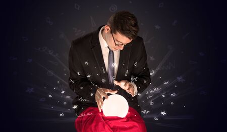 Gorgeous businessman looking to inspiration in a magic ball in his lap and doodle conceptの写真素材