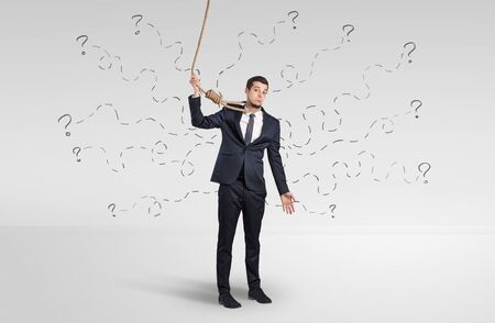 Concept of stressed businessman with question marks around himの写真素材