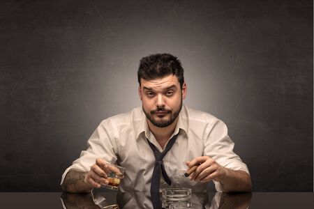 Young drunk man at his office with free dark copyspaceの写真素材