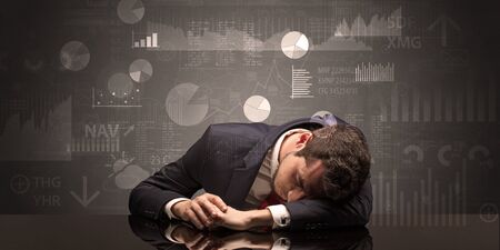 Young businessman sleeping with charts, graphs and reports on the backgroundの写真素材