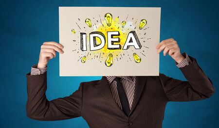 Young person holding white paper with new idea concept in front of his headの写真素材