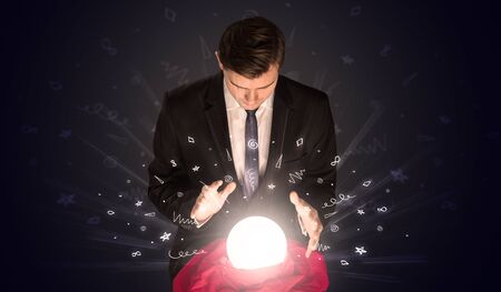 Gorgeous businessman looking to inspiration in a magic ball in his lap and doodle conceptの写真素材
