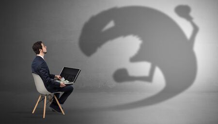 Young businessman staying and negotiate with a monster shadowの写真素材