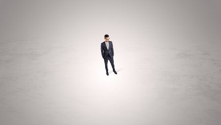 Young businessman standing alone in the middle of an empty spaceの写真素材