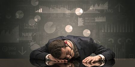 Young businessman sleeping with charts, graphs and reports on the backgroundの写真素材