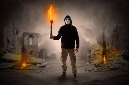 Destroyed place after a catastrophe with man and burning flambeau conceptの写真素材