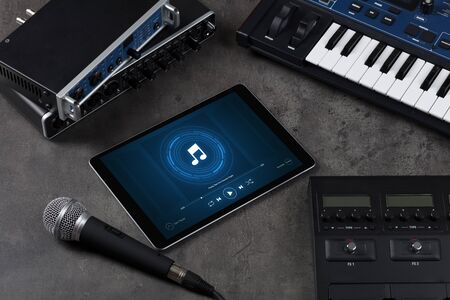 Playing song on tablet with electronic music instruments aroundの写真素材
