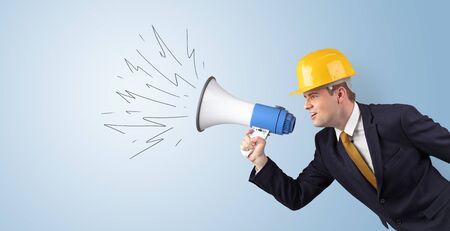 Young architect constructor yelling with megaphone and copyspaceの写真素材