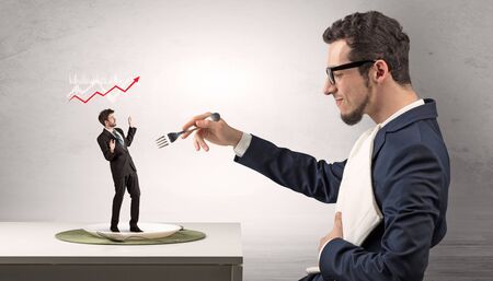 Big boss eating small businessman with knife and forkの写真素材