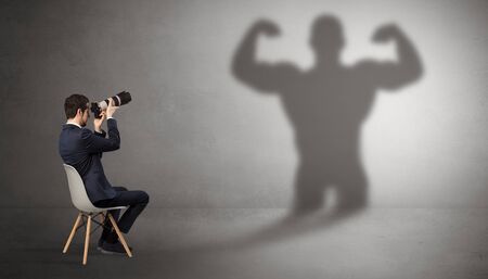 Businessman staying and offering stuffs to a shadow businessmanの写真素材