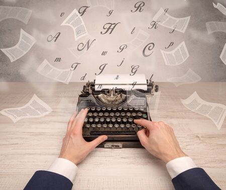First person perspective hand typewriting with flying documents aroundの写真素材