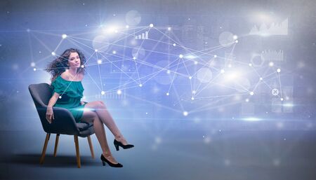 Elegant woman sitting in a sofa with network and connection conceptの写真素材
