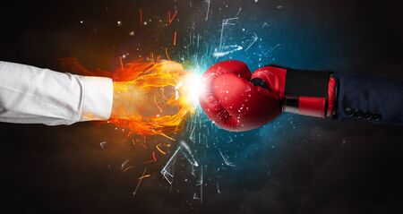 Two hands fighting and breaking glass into small pieces with fire and water conceptの写真素材