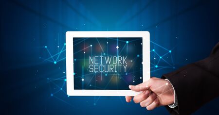 Young business person working on tablet and shows the digital sign: NETWORK SECURITYの写真素材