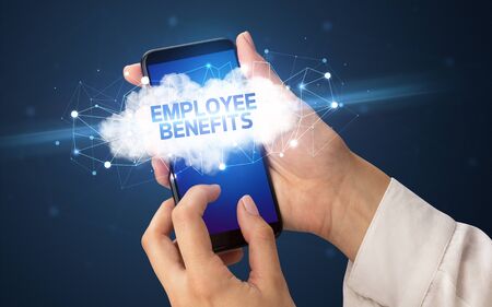 Female hand touching smartphone with EMPLOYEE BENEFITS inscription, cloud business conceptの写真素材