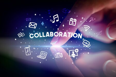 Finger touching tablet with drawn social media icons and COLLABORATION inscription, social networking conceptの写真素材