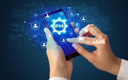 Female hand holding smartphone with IPV4 abbreviation, modern technology conceptの写真素材
