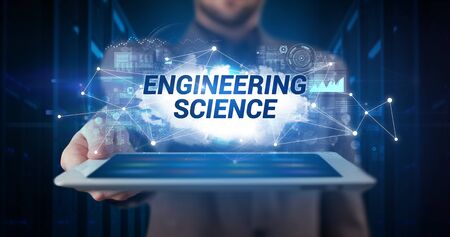 Young business person working on tablet and shows the inscription: ENGINEERING SCIENCEの写真素材