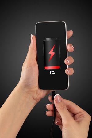 Elegant hand charging cellphone with low batteryの写真素材