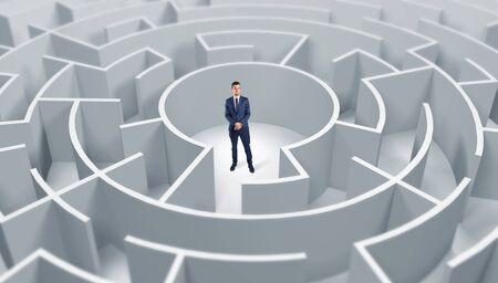Young businessman standing in a middle of a 3d round mazeの写真素材