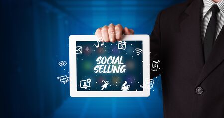 Young business person working on tablet and shows the inscription: SOCIAL SELLINGの写真素材